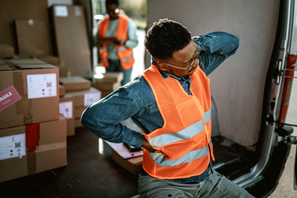 A man in an orange vest sits representing legal aid for spinal cord injuries in Cherry Hill, NJ
