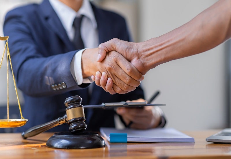 A Transportation Security Administration (TSA) lawyer shaking hands with a client.