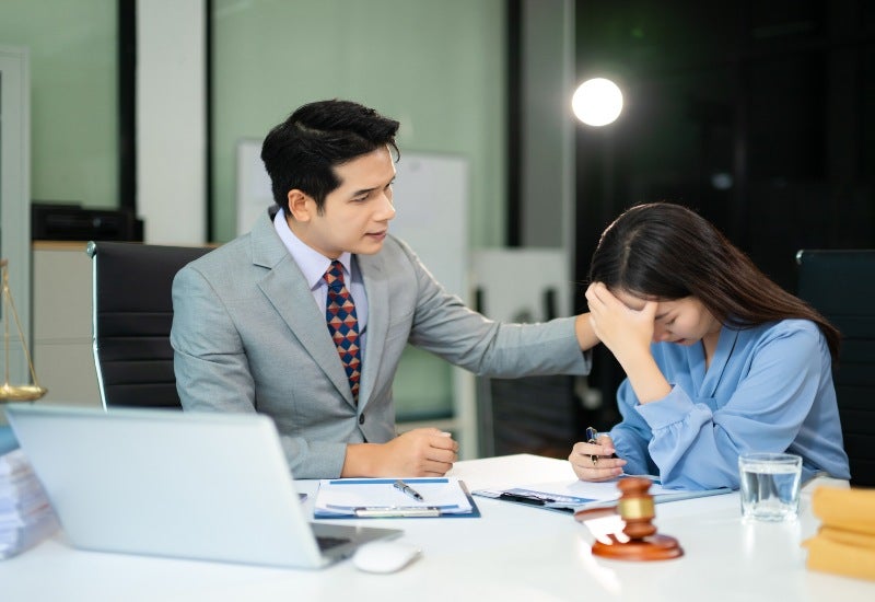 An attorney providing legal support during a psychological injury consultation.
