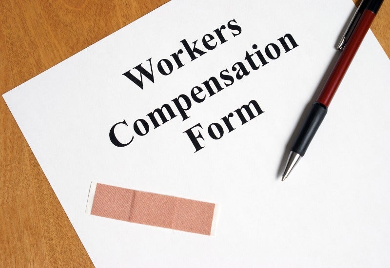 Workers' compensation form with pen and medical bandage on desk