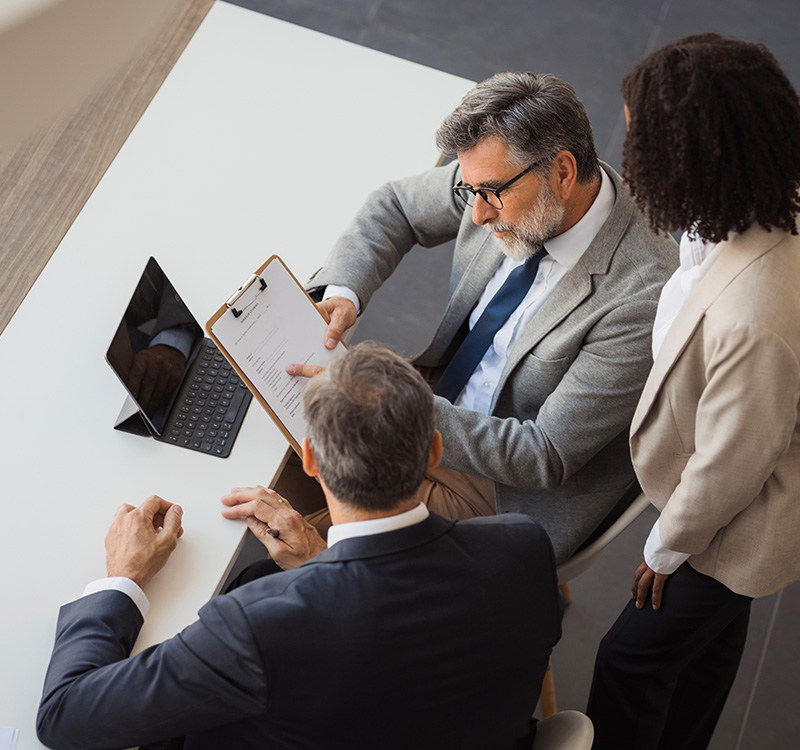 Business colleagues reviewing contract documents in office meeting