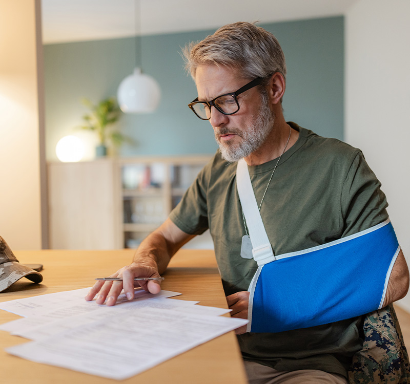 Man with broken arm reading papers
